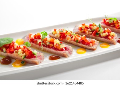 Appetizer With Tuna Tartar, Seasonal Vegetables And Greens On White Restaurant Plate Isolated. Macro Photo Of Delicious Healthy Red Fish Tatar Or Tar-tar Entree Closeup