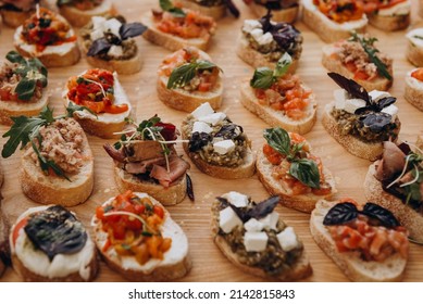 Appetizer - appetizer to wake up the appetite. Sandwiches on the table: bruschetta with butter, fish, cheese, mozzarella, tomatoes, basil