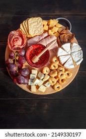 Appetizers board with assorted cheese, meat, sausage rosette, grape and salty cookies. Charcuterie and cheese platter. Top view