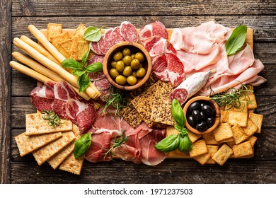 Appetizers with differents antipasti, charcuterie, snacks and red wine. Sausage, ham, tapas, olives and crackers for buffet party. Top view, flat lay - Shutterstock ID 1971237503