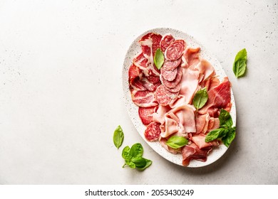 Appetizers with differents antipasti, charcuterie, snacks and red wine on white background. Sausage, ham, tapas, olives and crackers for buffet party. Top view, flat lay - Shutterstock ID 2053430249