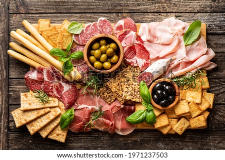 Appetizers with differents antipasti, charcuterie, snacks and red wine. Sausage, ham, tapas, olives and crackers for buffet party. Top view, flat lay