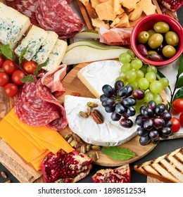 Appetizers Table. Cheese, Fuits And Meat Board On Dark  Background. Top View