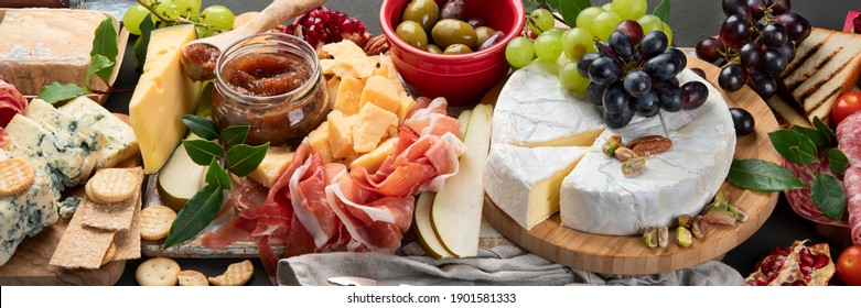 Appetizers table. Cheese, fuits and meat board on dark  background. Panorama banner
 - Powered by Shutterstock