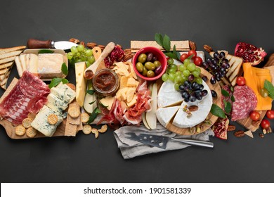 Appetitztisch. Käse, Gürtel und Fleischbrett auf dunklem Hintergrund. Draufsicht mit Kopienraum