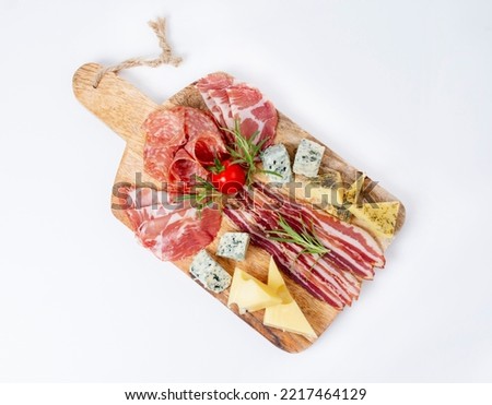 Appetizers table with different antipasti, charcuterie, snacks and cheese. Buffet party. Wooden cutting board isolated on white background, top view	