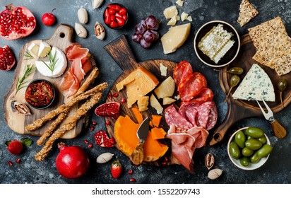 Appetizers table with italian antipasti snacks. Brushetta or authentic traditional spanish tapas set, cheese variety board over black stone background. Top view, flat lay - Powered by Shutterstock