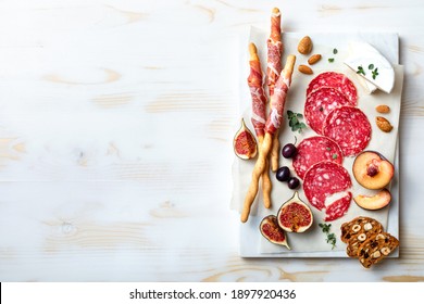 Appetizers table with italian antipasti snacks. Brushetta or authentic traditional spanish tapas set, cheese and meat variety board over wooden background. Top view, flat lay - Powered by Shutterstock