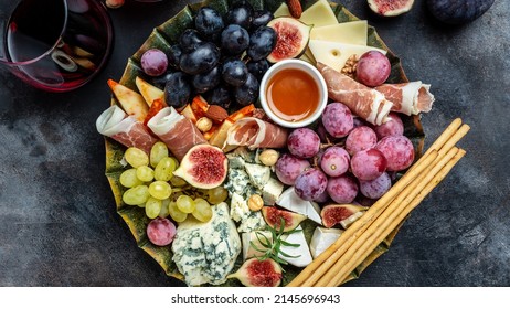 Appetizers Table With Italian Antipasti Snacks And Wine In Glasses. Cheese, Ham, Nuts, Fruit, Bread Sticks. Delicious Balanced Food Concept.