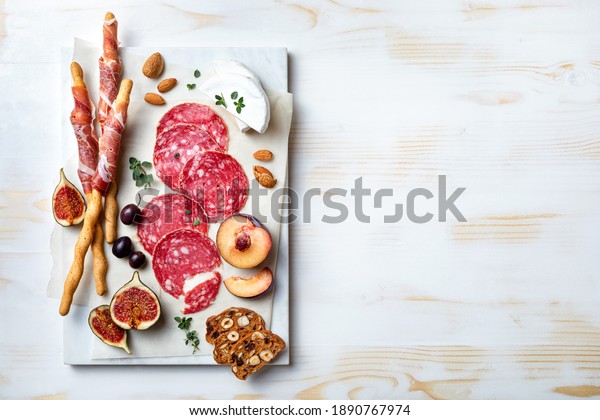 Appetizers table
with italian antipasti snacks. Brushetta or authentic traditional
spanish tapas set, cheese and meat variety board over wooden
background. Top view, flat
lay