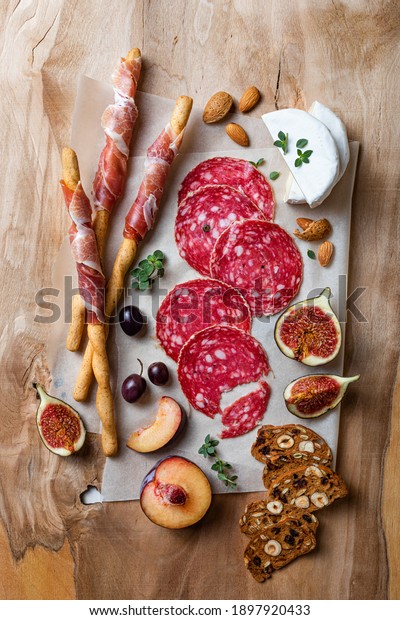 Appetizers table\
with italian antipasti snacks. Brushetta or authentic traditional\
spanish tapas set, cheese and meat variety board over wooden\
background. Top view, flat\
lay