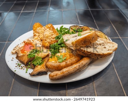 Appetizing breakfast spread with fried eggs juicy sausages crispy potatoes mushrooms fresh parsley and bread