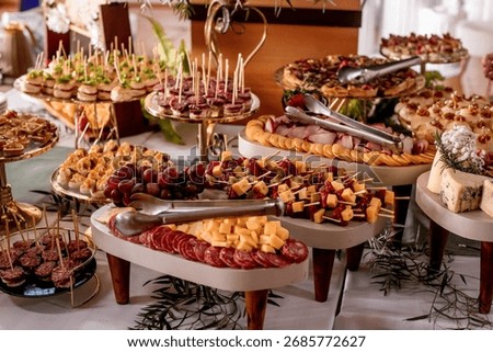 Appetizing cold snack table with salami cheese and fruit
