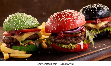 Appetizing hamburgers with colorful buns and meat cutlets served on table with French fries - Shutterstock ID 1985807963