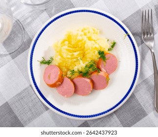 Appetizing mashed potatoes served on plate with meat sausage