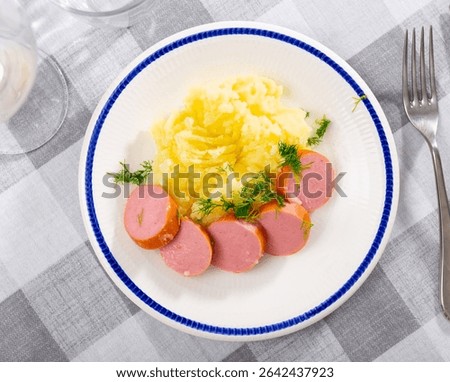 Appetizing mashed potatoes served on plate with meat sausage