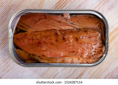 Appetizing Natural Frigate Mackerel Fillets In Open Tin Can On Wooden Table 

