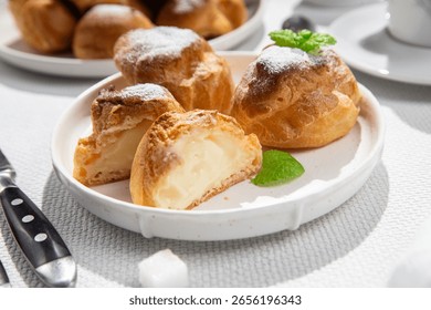 Appetizing Profiteroles with custard. Eclairs