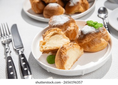Appetizing Profiteroles with custard. Eclairs
