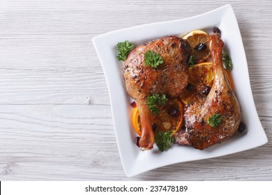 Appetizing roasted duck leg with oranges and raisins on a white plate close up. top view of a horizontal  - Powered by Shutterstock