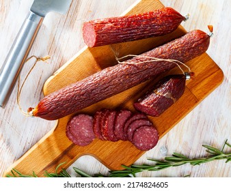 Appetizing Russian Dry Smoked Pork Sausage With Rosemary On Wooden Background