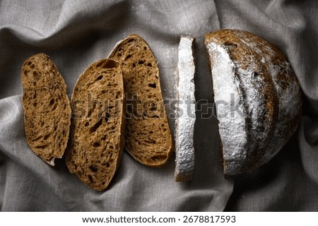 Appetizing rye sourdough bread slices on a rustic linen towel. Artisan farmhouse-style loaf close up