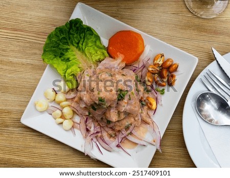 Appetizing seviche - typical Peruvian dish from fresh raw fish marinated in lime juice served with vegetables