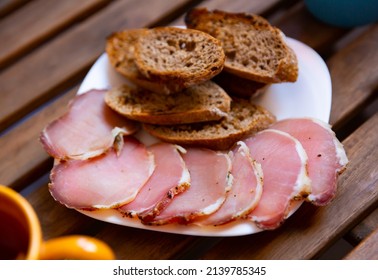 Appetizing Sliced Jerky Boneless Pork Tenderloin Served With Toasted Grain Bread On Wooden Background. Meat Snack..