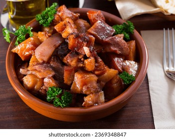 Appetizing stewed chopped pork snouts (Morro de cerdo) decorated with fresh parsley