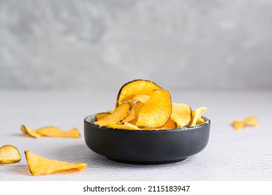 Appetizing sweet potato chips in a bowl on the table. Homemade snack. Copy space
