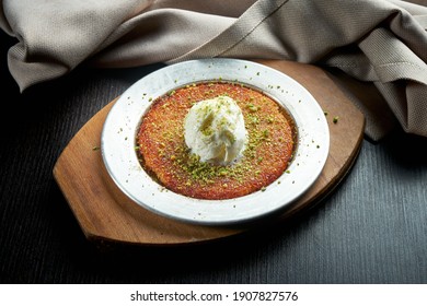 Appetizing Turkish sweetness Kanafeh made with shredded filo pastry with honey, pistachios and white ice cream