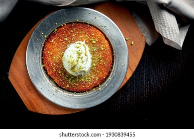 Appetizing Turkish sweetness Kanafeh made with shredded filo pastry with honey, pistachios and white ice cream