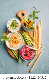 Appetizing Vegetarian Healthy Dips Sauces In Small Bowls With Cut Vegetables On Cutting Board. View From Above. Healthy Detox Weight Loss Concept. 