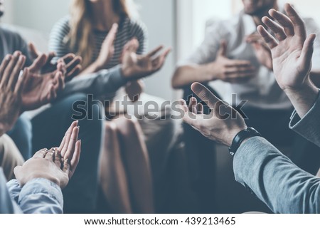 Applauding their success. Close-up of people applauding while sitting in circle together