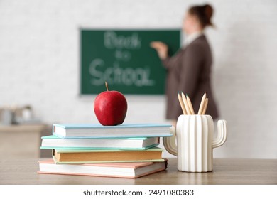 Apple, books and pencils on desk in classroom. Back to school concept - Powered by Shutterstock