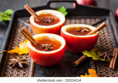 Apple cider with cinnamon sticks and anise star in apple cups - Powered by Shutterstock