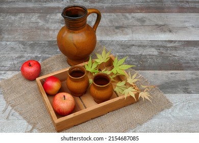 Apple Cider In Clay Jug And Mug On A Wooden Tray.