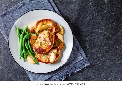 Apple Cider Glazed Pork Chops with green bean and caramelized apple slices on a plate with cutlery, flat lay, free space