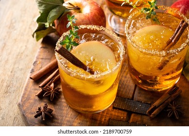 Apple cider margarita with brown sugar rim, cinnamon and fresh thyme, fall cocktail or mocktail idea in a rustic setting