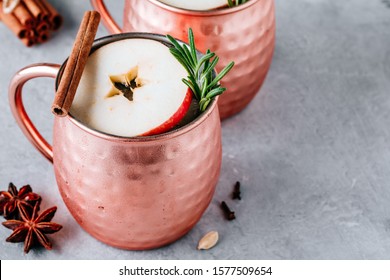 Apple Cider Moscow Mule Cocktail With Cinnamon Stick And Rosemary In Copper On Gray Concrete Stone Background