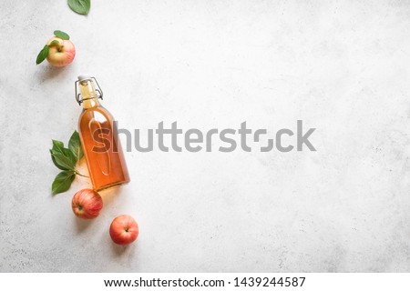 Apple cider vinegar or fermented fruit drink and organic apples on white, top view, copy space. Healthy eating and lifestyle concept.