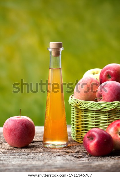 Apple\
cider vinegar in glass bottle and fresh\
apples