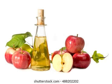 apple cider vinegar in a glass vessel and red apples isolated on white background