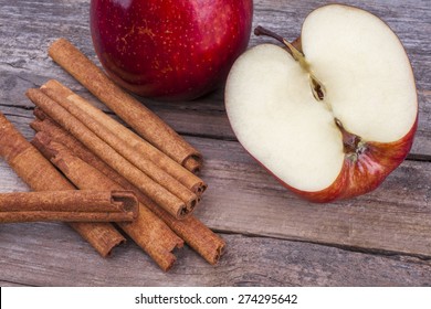 Apple And Cinnamon Whole And Halved On Wood Top View Close Up