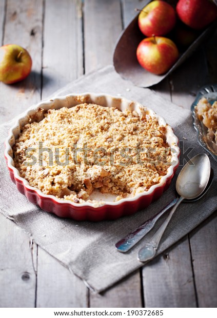 Apple\
crumble on the wooden background with apples\
