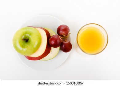 Apple, Grapes On A Plate And A Glass Of Orange Juice. Top View