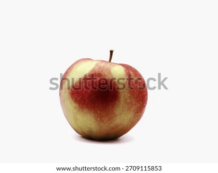 apple with heart-shaped pale patch on white studio surface, emotive closeup evokes charm and romance, quirky