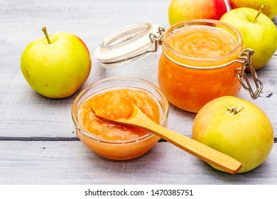 Apple Jam, Confiture, Chutney In A Glass Jar. Homemade Preservation Concept. With Fresh Apples, Rustic Spoon On Gray Wooden Boards Background, Close Up