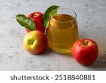 Apple juice in the glass with apples