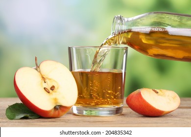 Apple juice pouring from red apples fruits in summer into a glass - Shutterstock ID 204835342